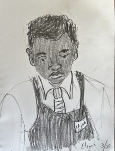 A teenaged boy with dark, curly hair looks down to his task. He wears a white collared shirt and a neatly tied tie. Over his shirt is a dark company apron with his nametag on the right of his apron. The nametag announces his name is "Elijah". His expression is focused on his task.